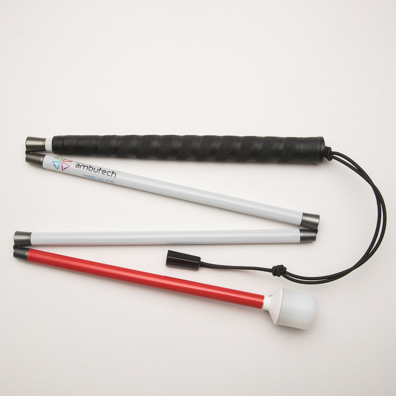 AmbuTech white mobility cane disassembled into four aluminum sections: ergonomic black grip at the top, two central white shafts with the Ambutech logo, and a white-and-red bottom section with a rounded white tip.